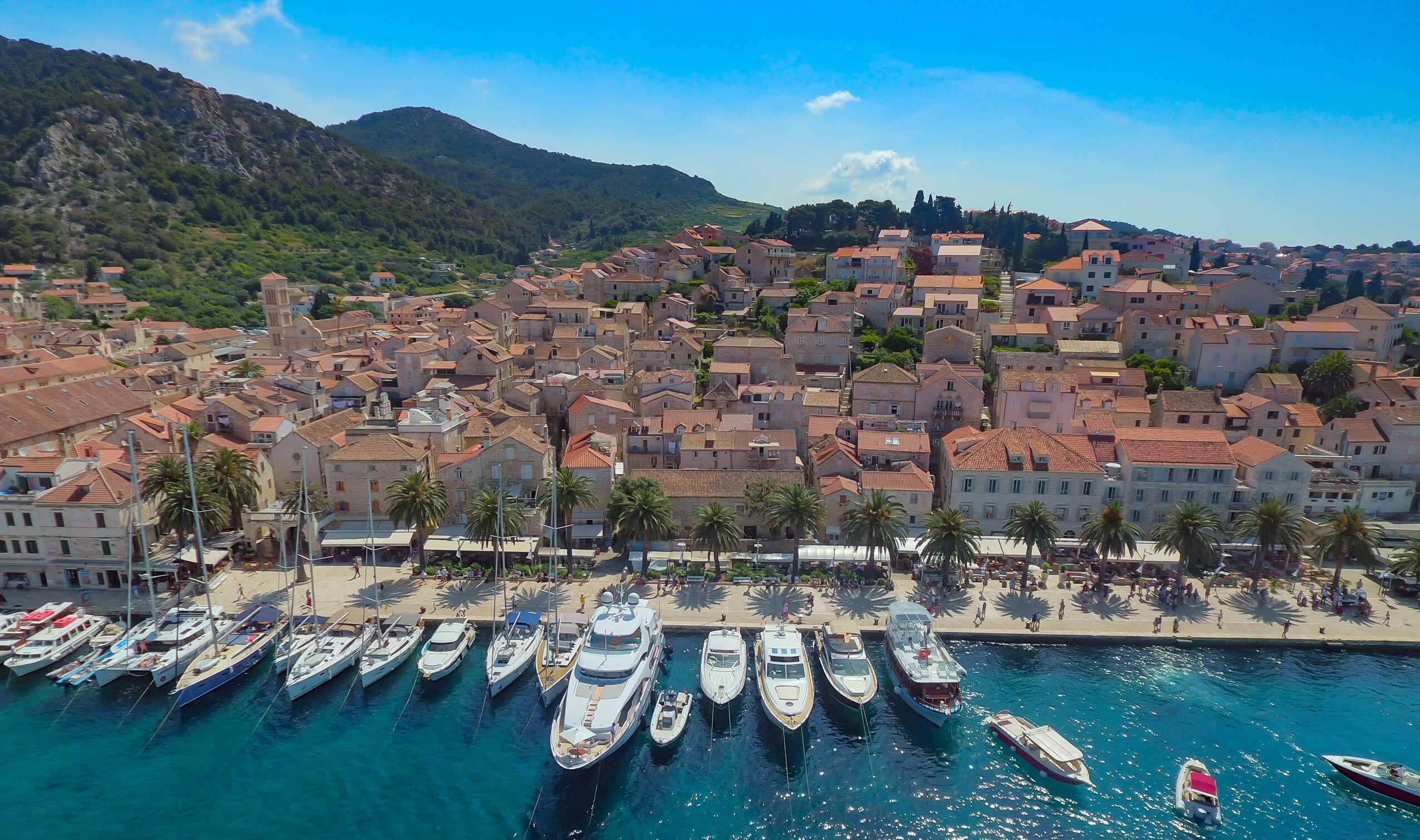 Hvar port waterfront with small boats, town quay and historic buildings along the coast